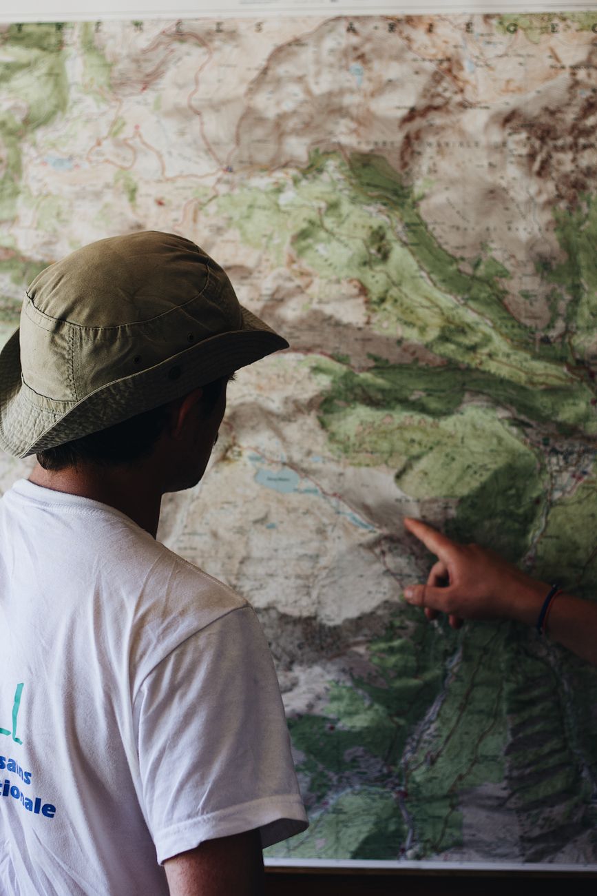 Travel writer examining maps and mountain scenery